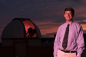 John Martin standing next to observatory dome
