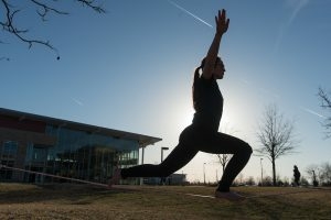 a student doing yoga on the quad